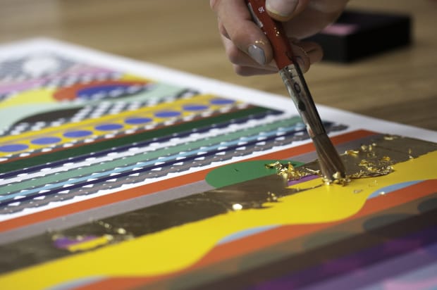 Applying gold leaf with brush to Beatriz Milhazes' print, Mother's Day
