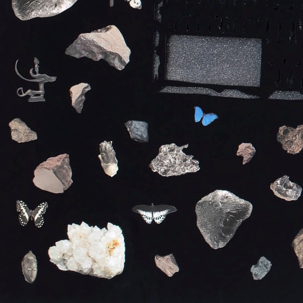 Detail from the left half of Villalongo's diptych showing rock crystals and African statuary against a black background.