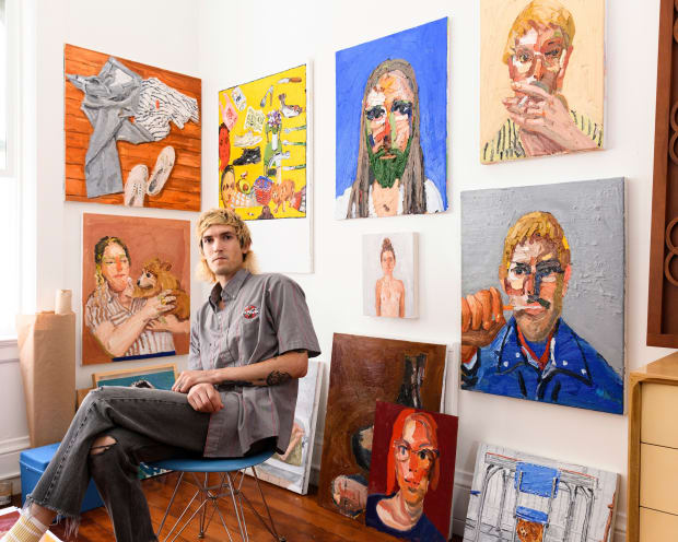 Artist Emilio Villalba sitting in his studio surrounded by his paintings 