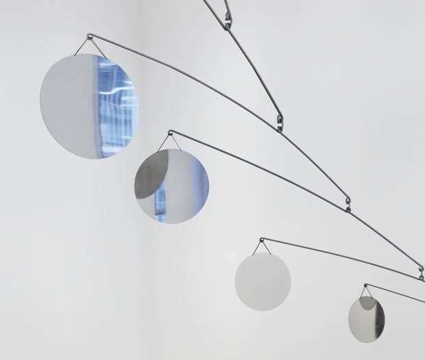 The hanging mobile A Rumble Across the Sky, 2022, whose composition is inspired by the work of Calder, juxtaposes an...