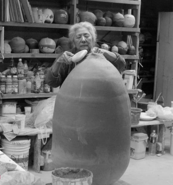 Takaezu paddling the top of a hand-built form. Photo Credit: Ben Eberle, 2003. Courtesy of The Family of Toshiko Takaezu.