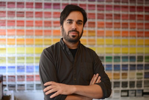 Photo of the artists Reuven Israel. He has brown hair and has his arms crossed