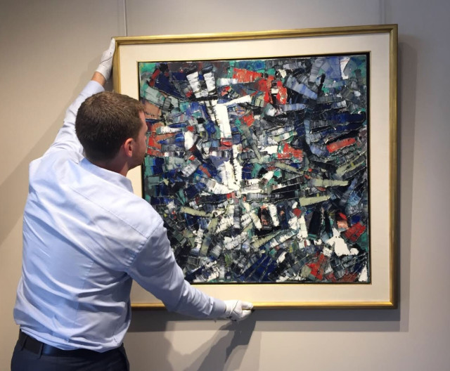 Craig Klinkhoff carefully hangs Passage, 1956 by Jean Paul Riopelle, which was sold by Alan Klinkhoff Gallery in 2018. 