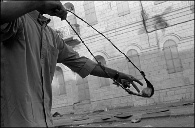 Larry Towell b. 1953 Bethlehem, West Bank [protester loading sling], 2000/2005 Signed, titled, and dated, in pencil au verso Gelatin silver print 35 1/4 x 51 in 89.54 x 129.54 cm