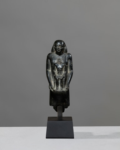 Egyptian theophorous figure, holding a seated statuette of Imhotep, Late Period, 27th-30th Dynasty, c.525-343 BC