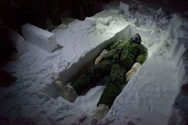 Louie Palu, A Canadian flight engineer on an Arctic Survival course at Resolute Bay, Nunavut seen lying in a trench during a lesson on cutting snow blocks. January is a month in the Arctic which sees nearly 24-hours of darkness and extreme cold and are normal conditions soldiers train to live in, 2017