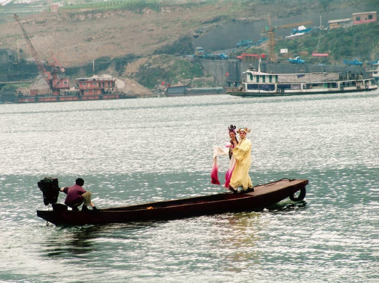 Two professional traditional (Chinese) opera actor and actress are on the little boat.