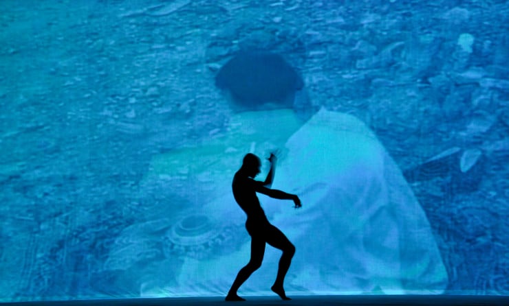 A male dancer is performing in front of Chen Qiulin's vedio work.
