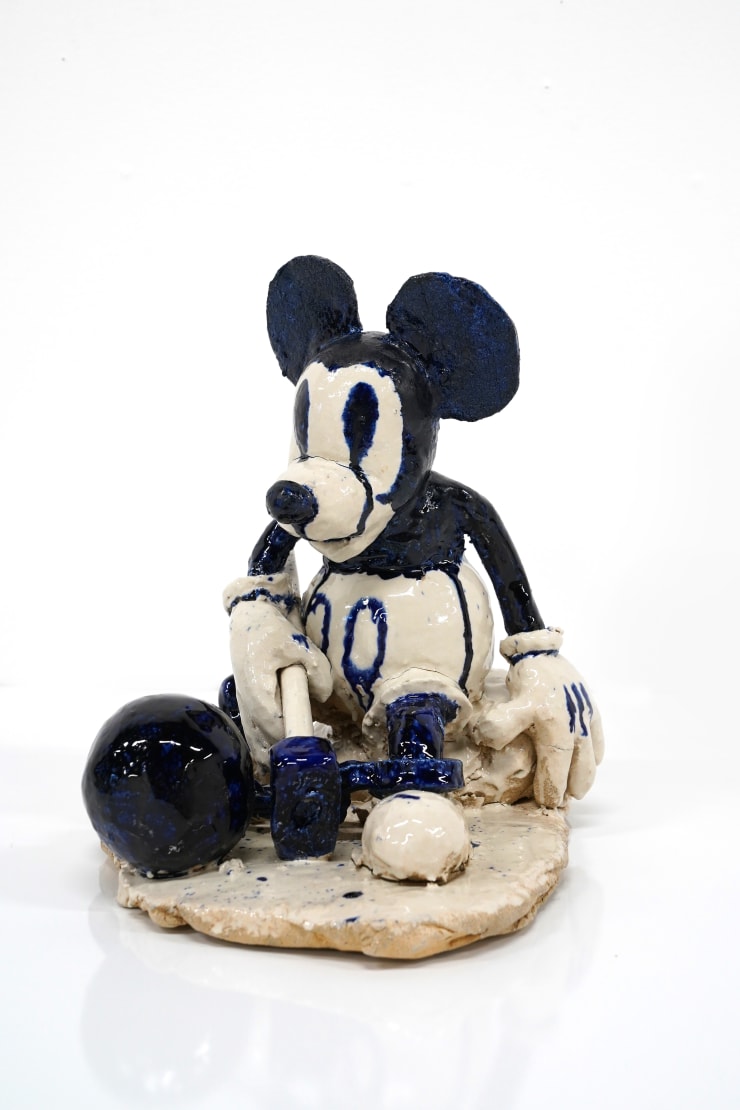 ceramic sculpture of mickey mouse with a ball and chain