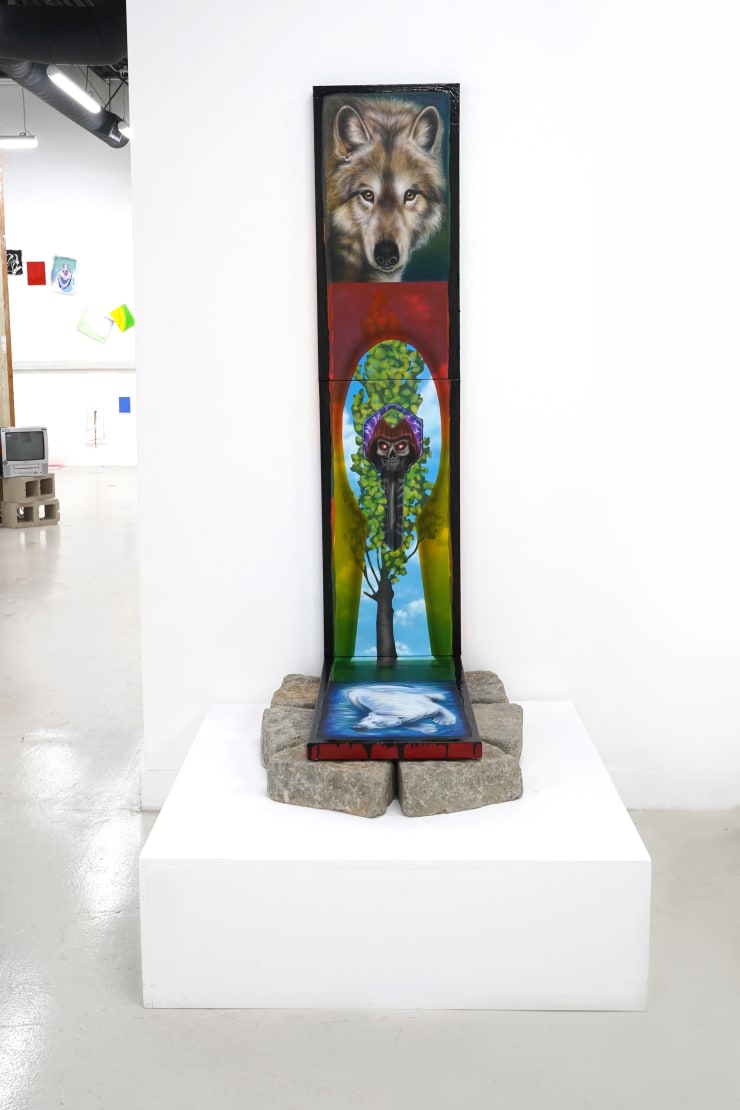 triptych painting positioned on top of a bed of rocks by Mia Scarpa. The artwork represents the tree of life