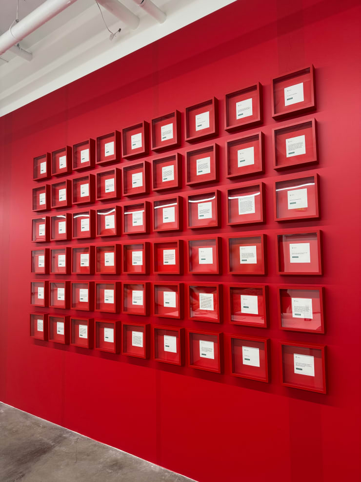 red wall with multiple framed artworks