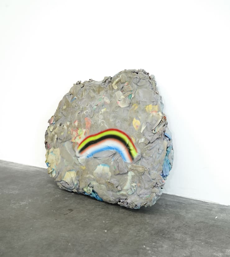 rock sculpture with frown face (rainbow)