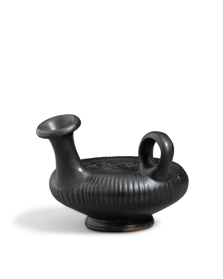 Greek, A Greek black-glazed pottery guttus, South Italy, circa 4th century BC