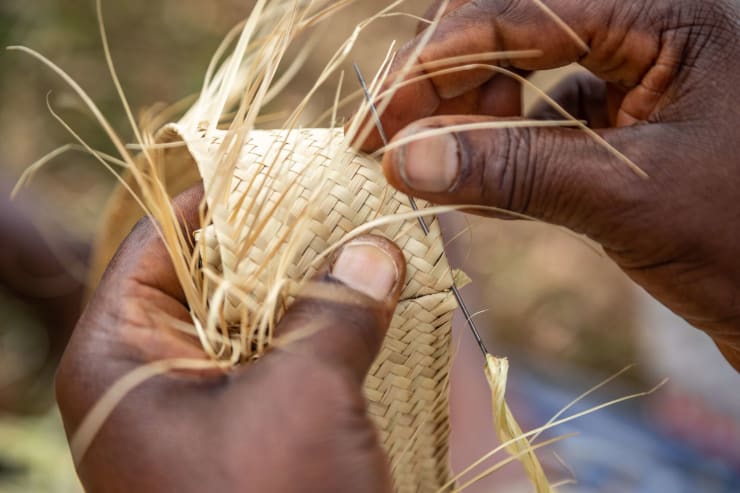 Acaye Kerunen preparing works for the Radiance – They Dream in Time exhibition during a workshop and performance at UNCC, Kampala