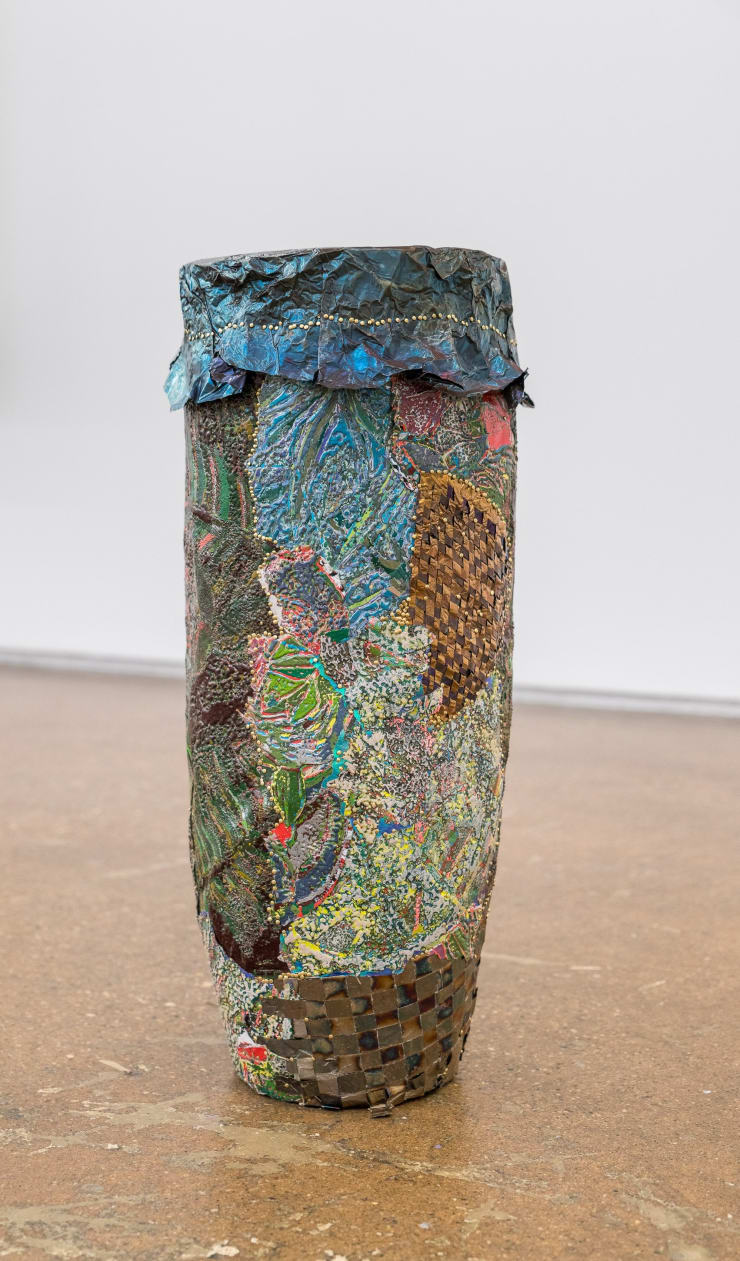 Kathia St. Hilaire Boula Six, 2024 oil based relief on canvas collage with skin lightening cream, steel, aluminum, banknotes, banana stickers, silkscreen, prices tags, paper, foam, nails, and tires, collaged onto foam 25 x 9 1/2 x 9 1/2 in 63.5 x 24.1 x 24.1 cm