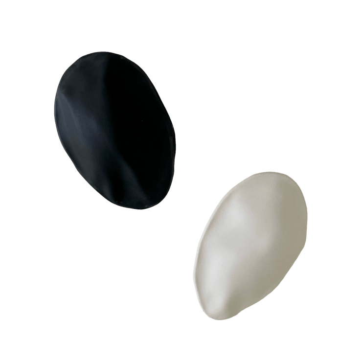 Black and white ceramic petals that can be arranged in multiple ways by slate gray gallery artist Angela Okajima-Kempinas