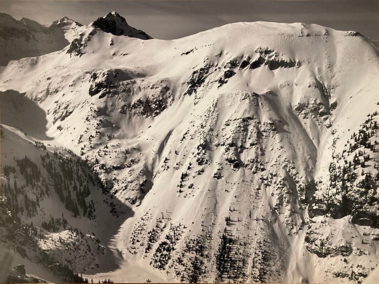 Black and white aerial photo of a snowy mountain by slate gray gallery photographer Brett Schrekengost