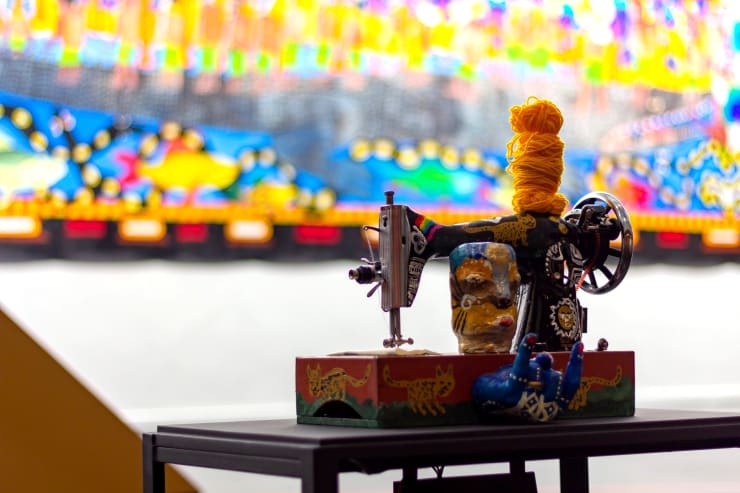 Em "Sobre os vínculos invisíveis", Novíssimo Edgar, interliga linhas por sete máquinas de costura, formando uma grande teia. A instalação retoma o ambiente do trabalho têxtil, junto a uma composição sonora, e oferece uma reflexão sobre os vínculos afetivos. Foto: Fábio Souza / MAM Rio