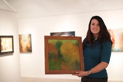 Karin Clarke with a painting by Mark Clarke. Photo by Athena Delene.