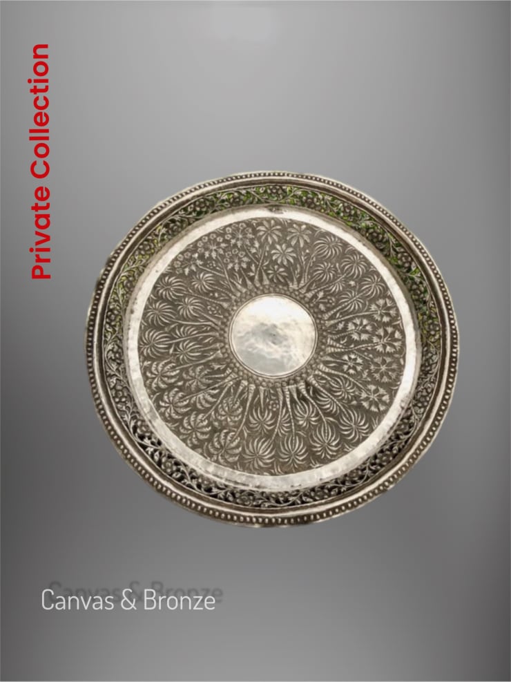 Ornate silver decorative plate with intricate floral patterns and central medallion design.