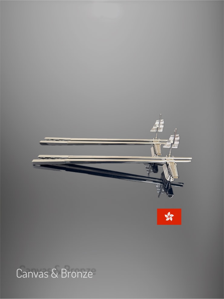 Three sleek, modern silver sailboats with intricate sails on a glossy reflective surface, featuring a small red emblem.