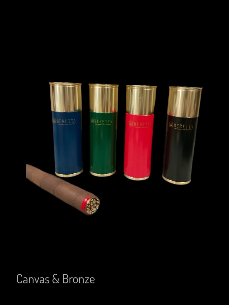 Four Beretta shotgun shell containers in blue, green, red, and black with gold lids, accompanied by a rolled brown document with a red seal, set against a black background.