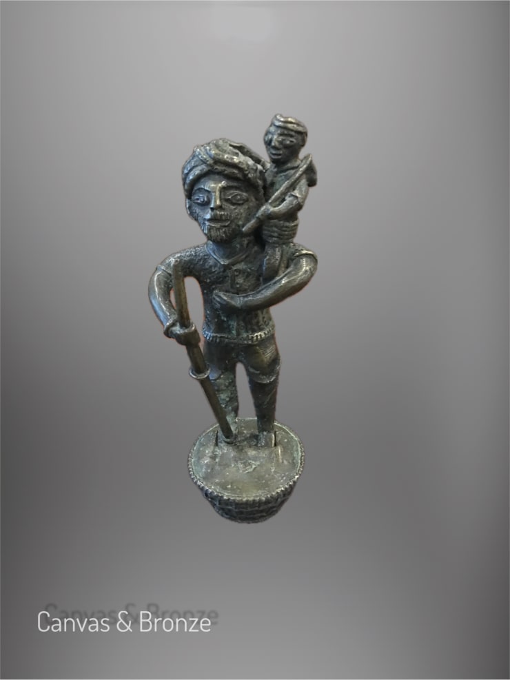 Bronze sculpture of a man carrying a child, with intricate detailing and a textured finish, showcasing cultural craftsmanship.