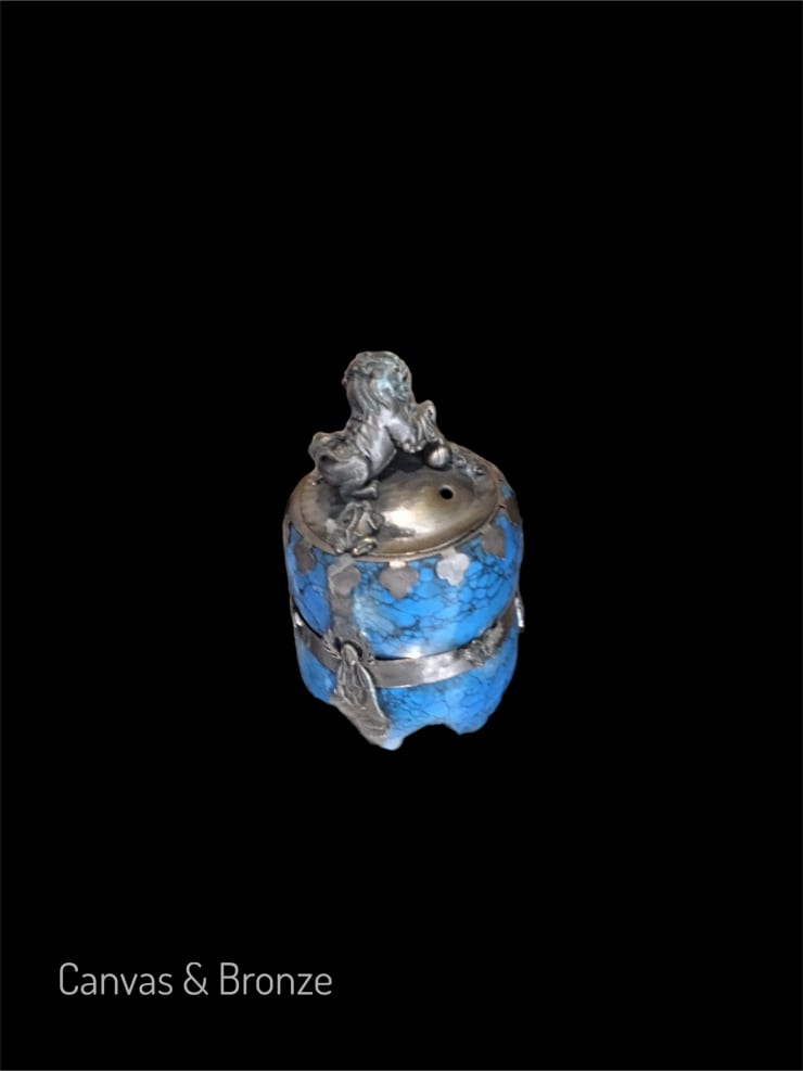 Antique blue and silver ornate container with intricate detailing on a black background.