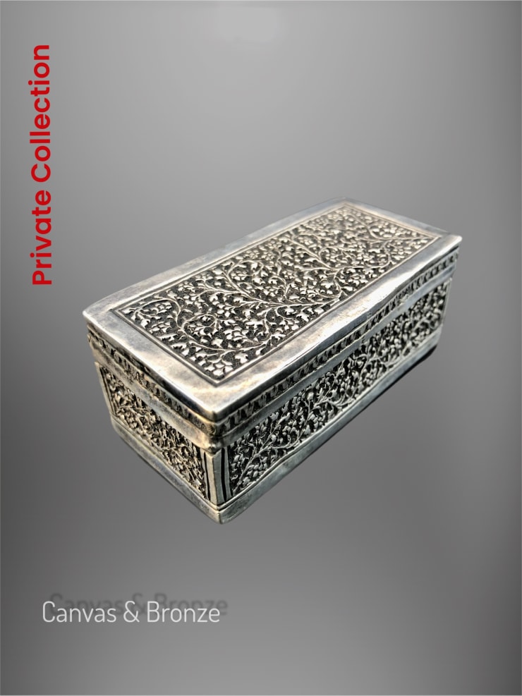 Ornate silver rectangular box with intricate floral engravings and a vintage design.