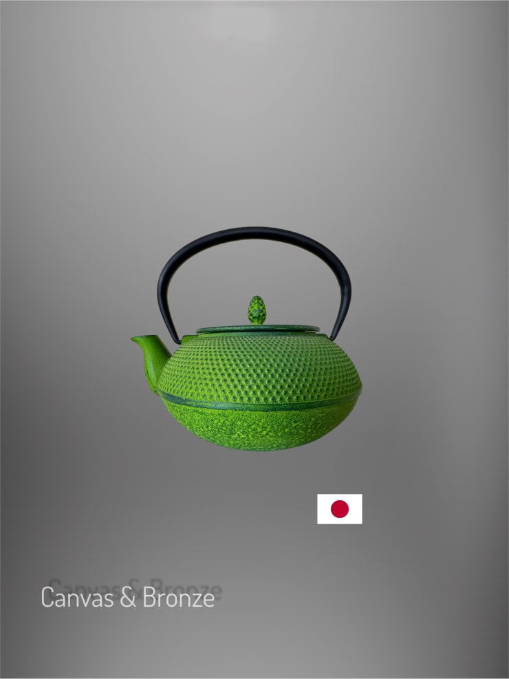 Green Japanese cast iron teapot with textured surface and black handle on a gray background.