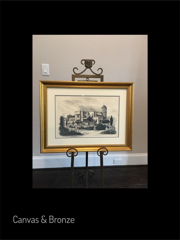 Framed architectural drawing of a historic building with intricate details and a water tower, displayed on an ornate stand.