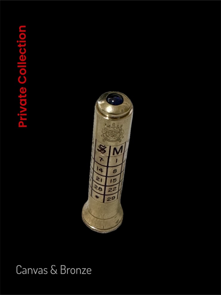 Brass cylindrical object with engraved numbers and a crest, set against a black background.