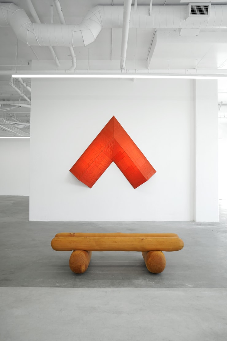 photo of installation of red light arrow and wooden log bench by Ryan Belli
