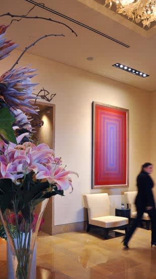 A hotel employee walks past one of four silk screen prints by Richard Anuszkiewicz in the lobby of the Four Seasons Hotel in Harbor East, Baltimore