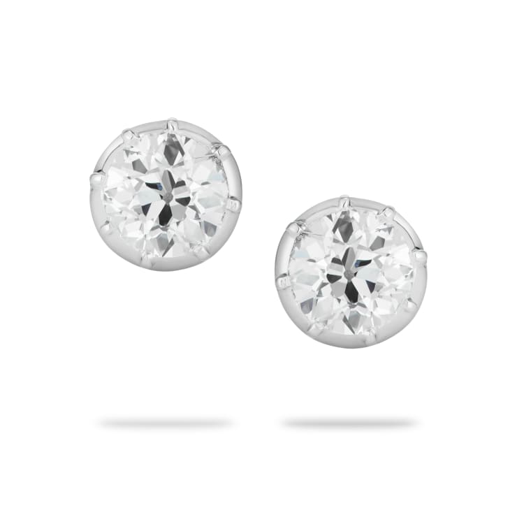 old cut diamond studs set in a cut-down setting of platinum on a white background
