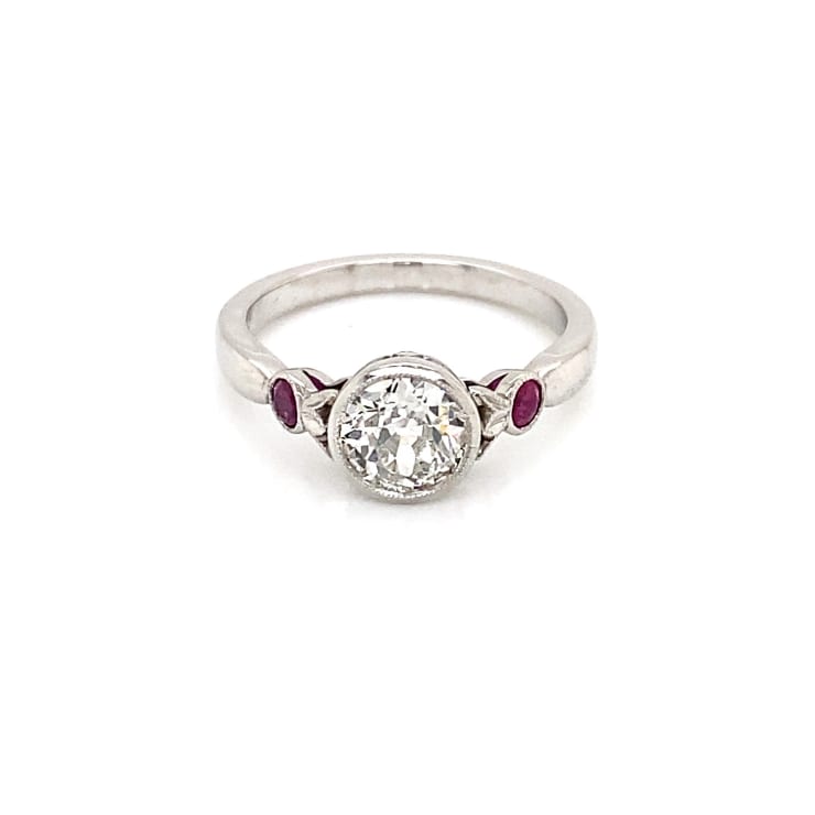 Bespoke old cut diamond platinum ring with ruby pomegranate details on the side. On white background