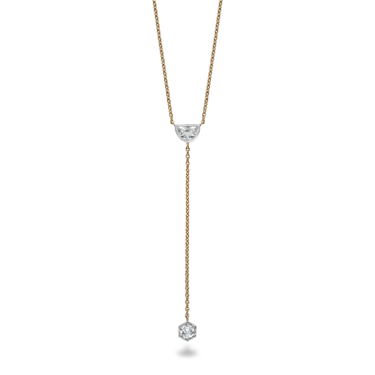 Lariat Pendant featuring a half moon diamond set in platinum with a millegrain edge with a round diamond hanging from gold chain set in a hexagon setting with millegrain edge on white background