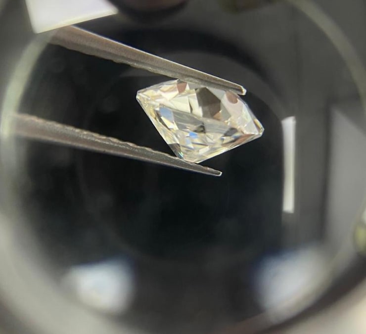Macro photo of an old cut diamond in tweezers.