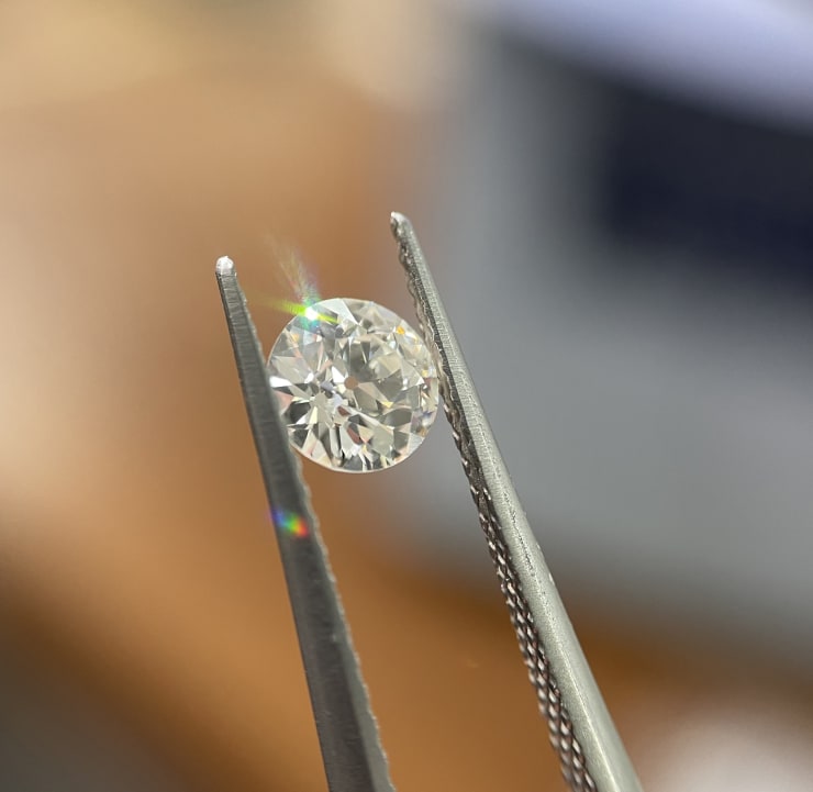 Old European cut diamond held in tweezers