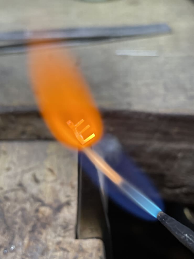 Aril jewels petal ring component being soldered on jewellers bench with flame.