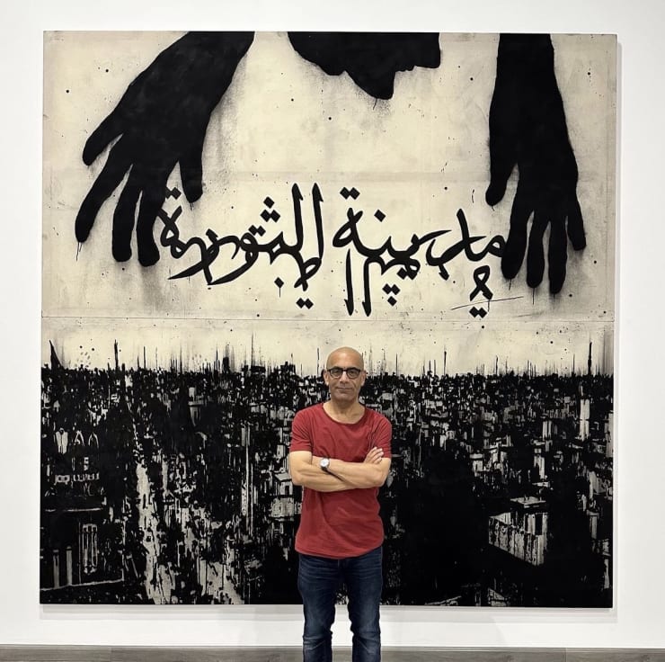 Sadik Kwaish Alfraji in front of his work, Create a City of Love and Nightmares, 2023, Indian ink and Charcoal on canvas, 301 x 302 cm,