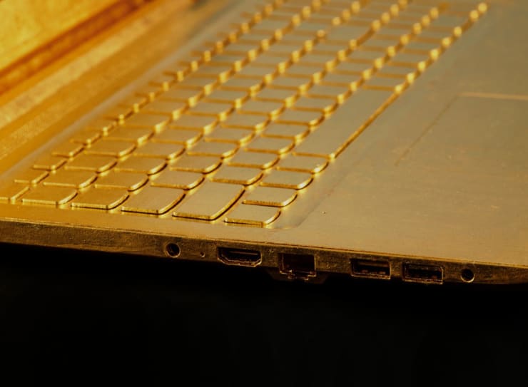 Keyboard detail of Article 3, a 2023 sculpture by Nic Phillipson, featuring a laptop computer gilded in 24 karat gold leaf