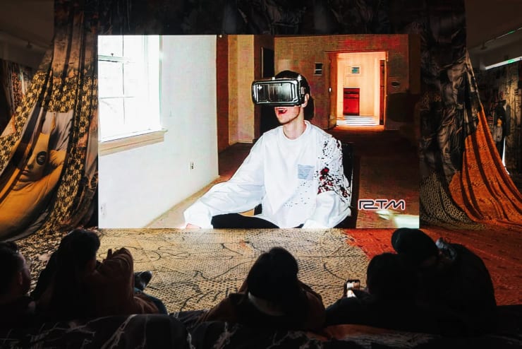 “Proof of Concept,” Jon Rafman’s show in Los Angeles, mines internet subcultures and content generated through artificial intelligence. Here, gallery-goers watch one of several short films.Credit...Aleksey Kondratyev for The New York Times