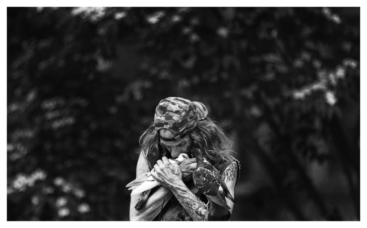Black and white photograph of a man with two doves in New York City.