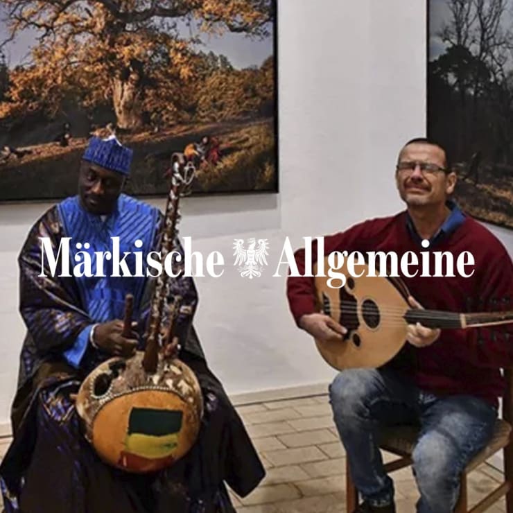 Kora-Spieler Djelifily Sako (l.) aus Mali und Oud-Spieler Marwan Alkarjousli aus Syrien sorgte für den musikalischen Teil des Jahresabschluss-Salons der Kunstfreunde Pritzwalk. Im Hintergrund zu sehen: Fotografien von Katerina Belkina. Quelle: Bernd Atzenroth