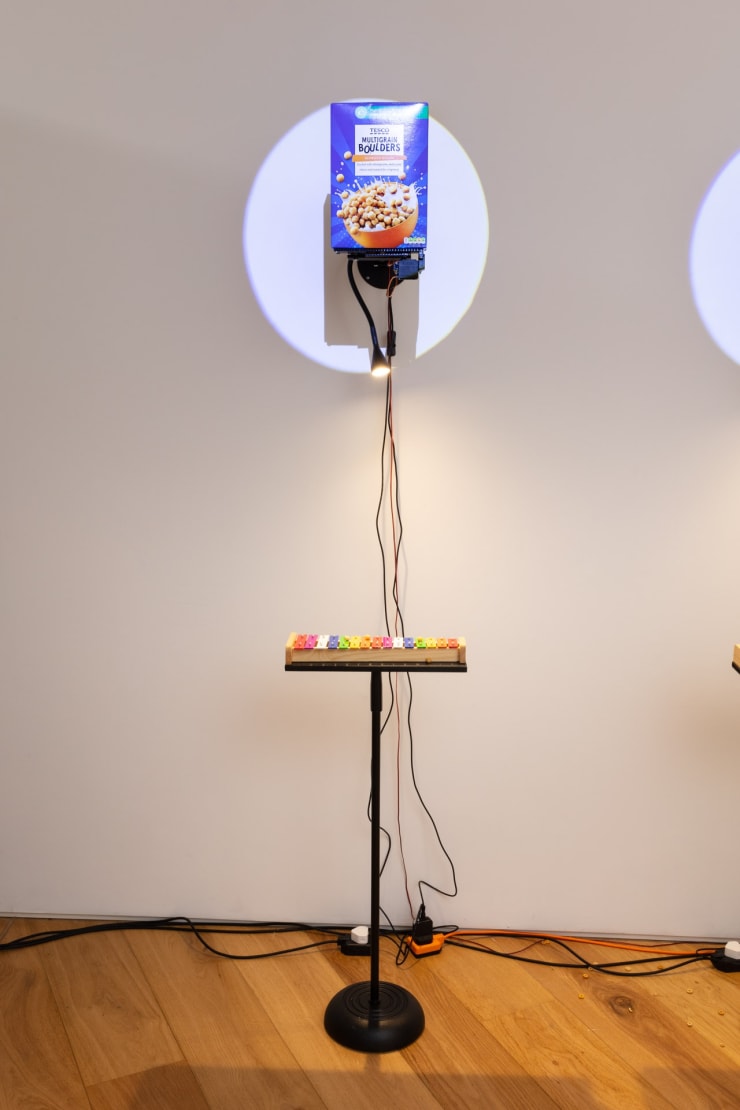 Clara Hastrup Do-Re-Mi-Fa-Ce-Re-Al (Boulders), 2023 Cereal, metal support structure, Arduinos, motors, 3D printed parts, xylophones, metal stand, spotlights