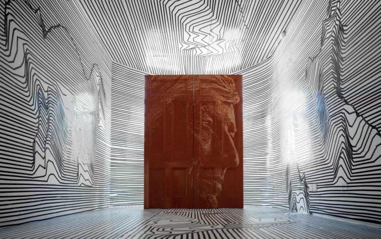 Alexandre Farto aka VHILS, 'Omnipresence Series #02', Hand-carved Old Wooden Doors, 241 x 175.5 cm (2020) at The Museum of the former German Governor’s residence, Tsing Tao, China. This specially commissioned artwork during the height of the pandemic for disCONNECT (2020) has travelled far. The portrait was carved directly onto the original doors of the library of the house in London, but due to travel restrictions, they were trucked from London to Vhils’ studio in Lisbon, trucked back to London installed and then shipped by air to Hong Kong for disCONNECT LDN.