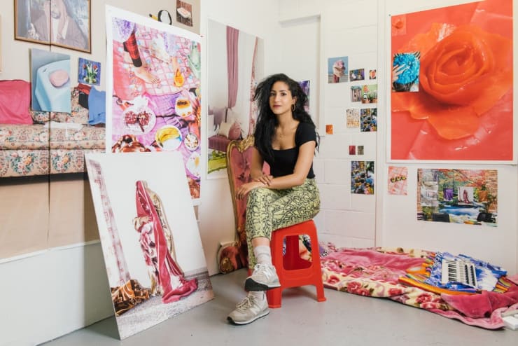 Farah Al Qasimi in her studio in Williamsburg, Brooklyn, surrounded by her photographs. They were all shot in the United Arab Emirates, where she grew up. (Gabriela Herman for The New York Times)