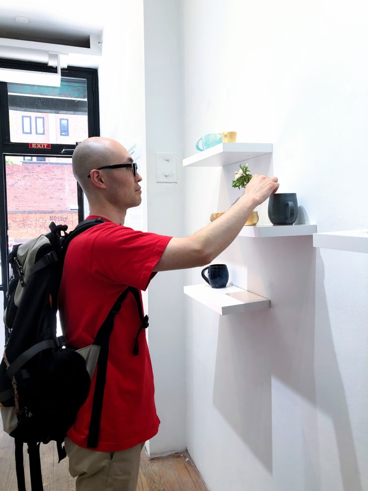 A gallery visitor interacting with Si Jie Loo's installation