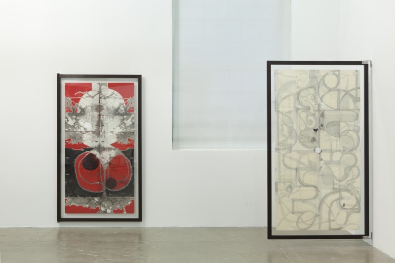 Two large vertical paintings of organic lines and shapes with muted colors are installed on hinges, to view the front and back. 